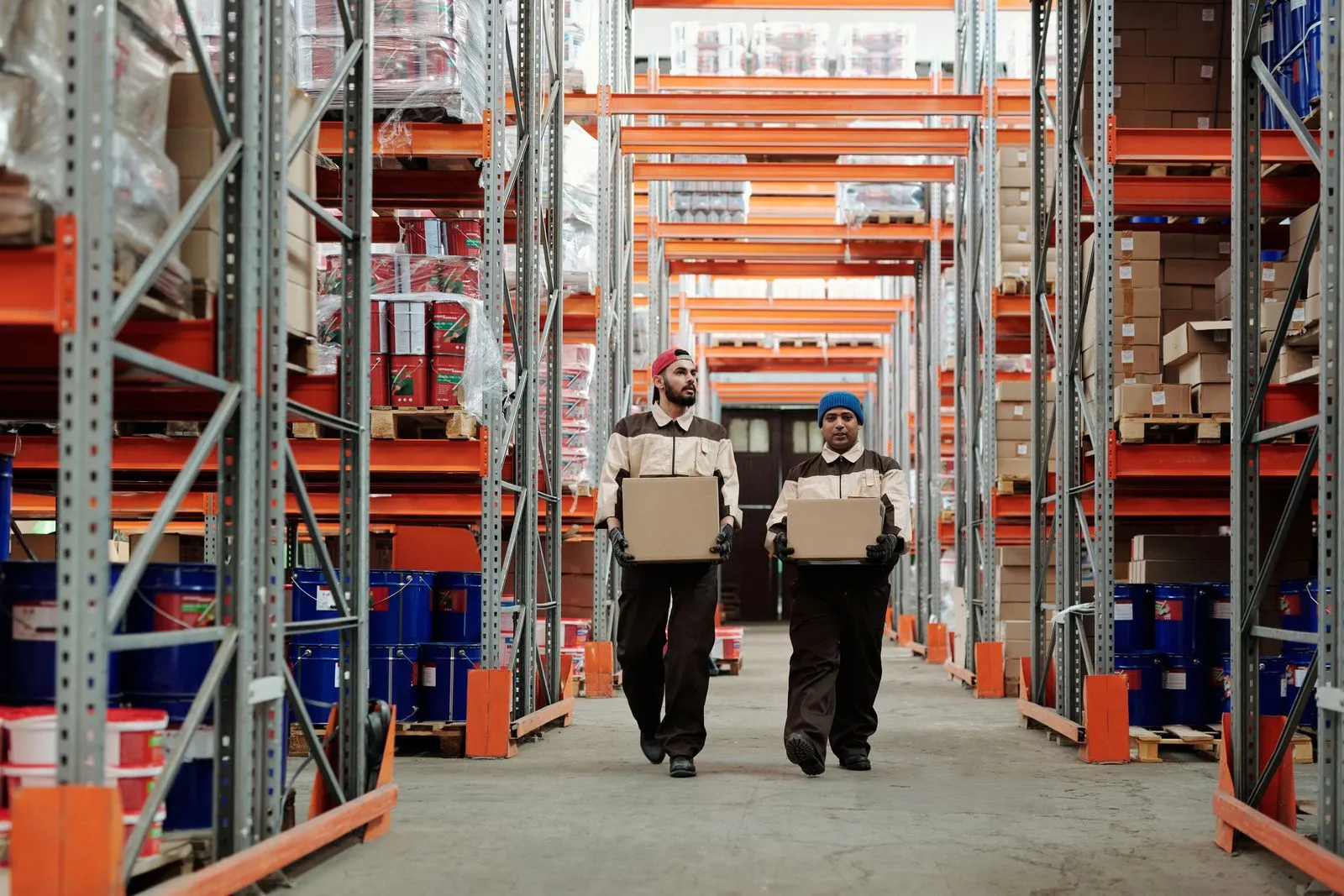 Staff moving cartons down a racked fulfilment aisle.